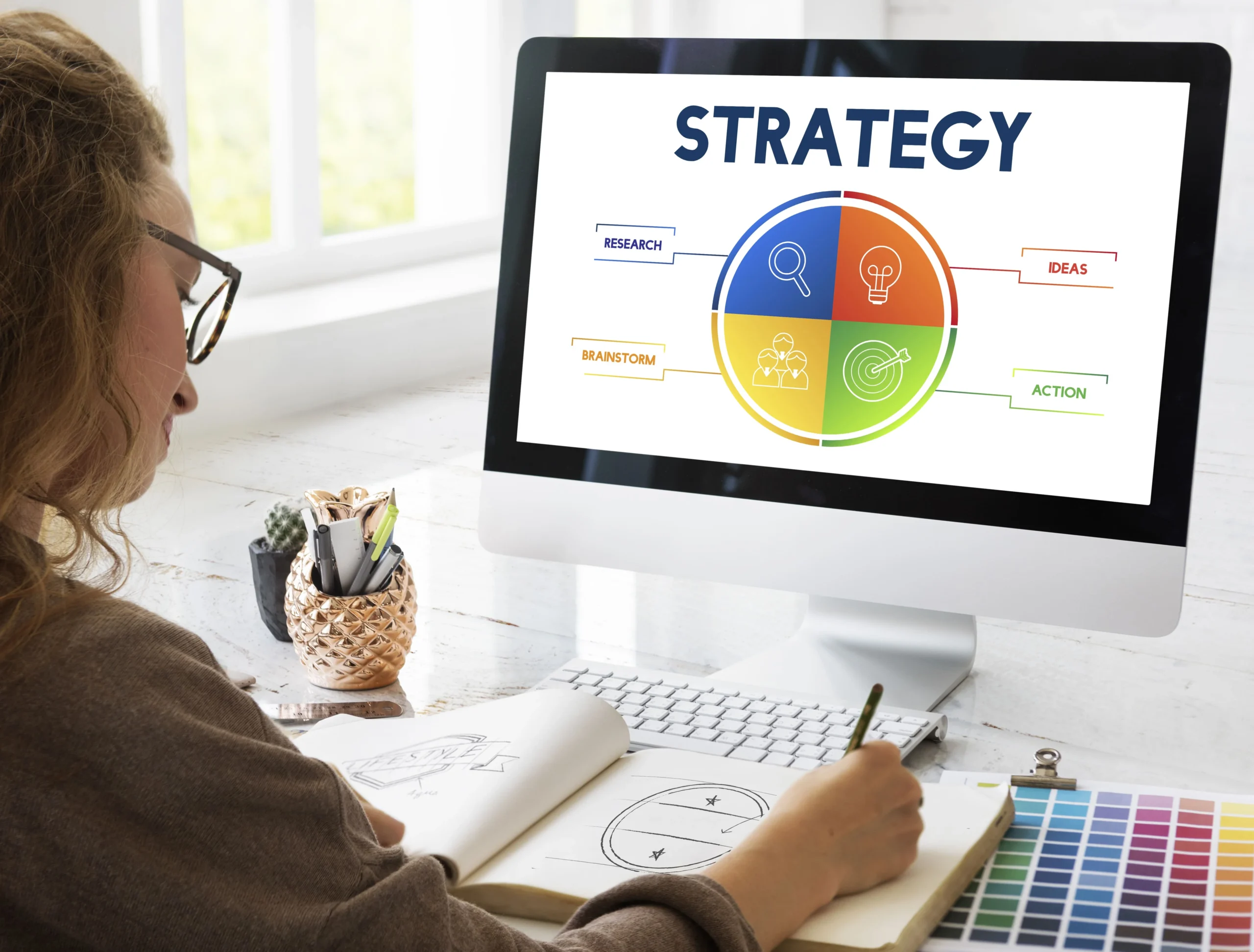 Woman working at a desktop computer showing a strategy diagram