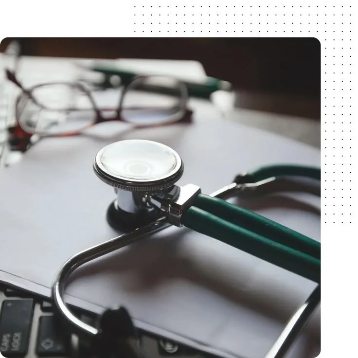 Stethoscope on a desk next to a laptop