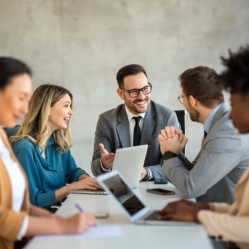 Business team meeting around a table with laptops