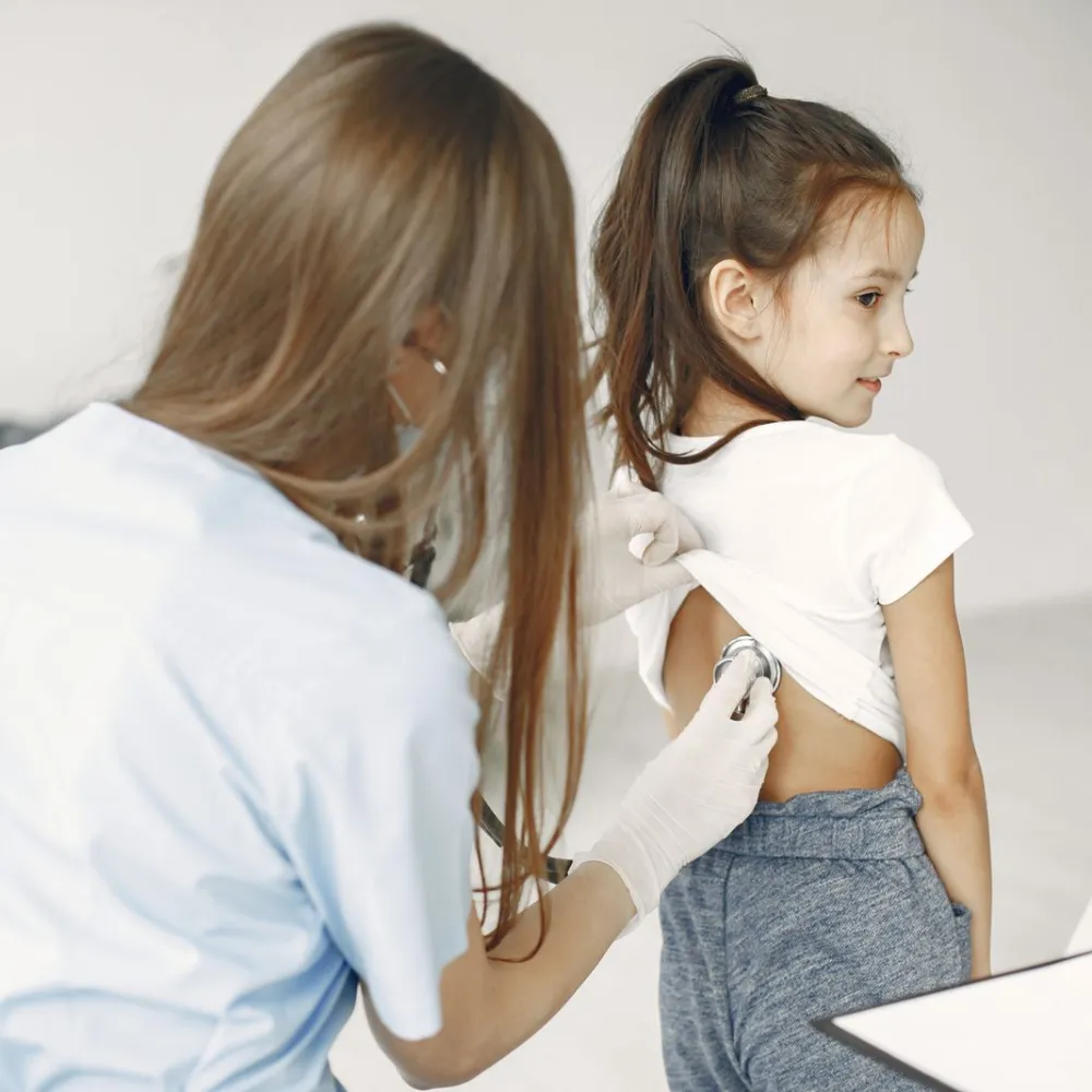Doctor examining a young girl with a stethoscope