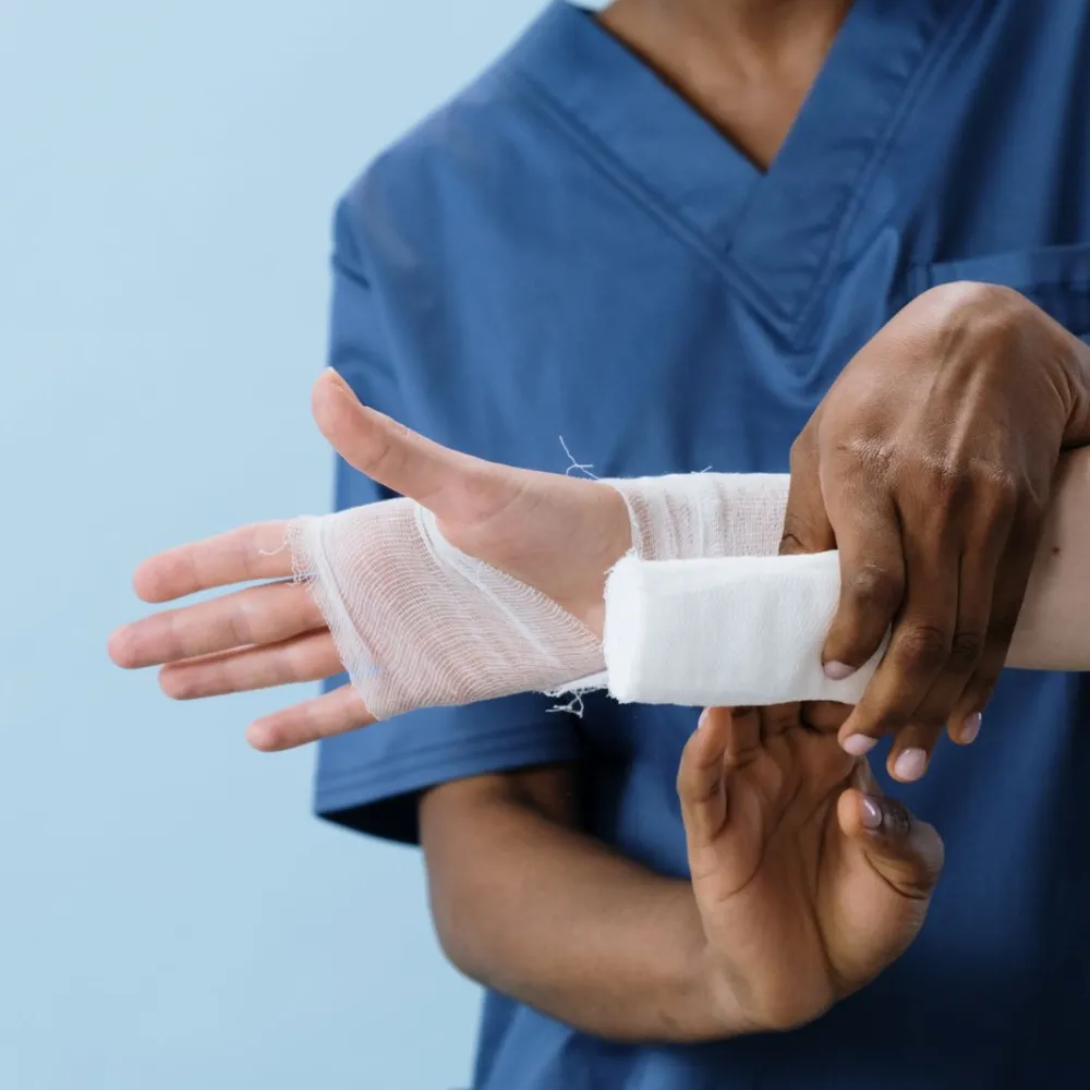 Clinician bandaging a patient's injured hand