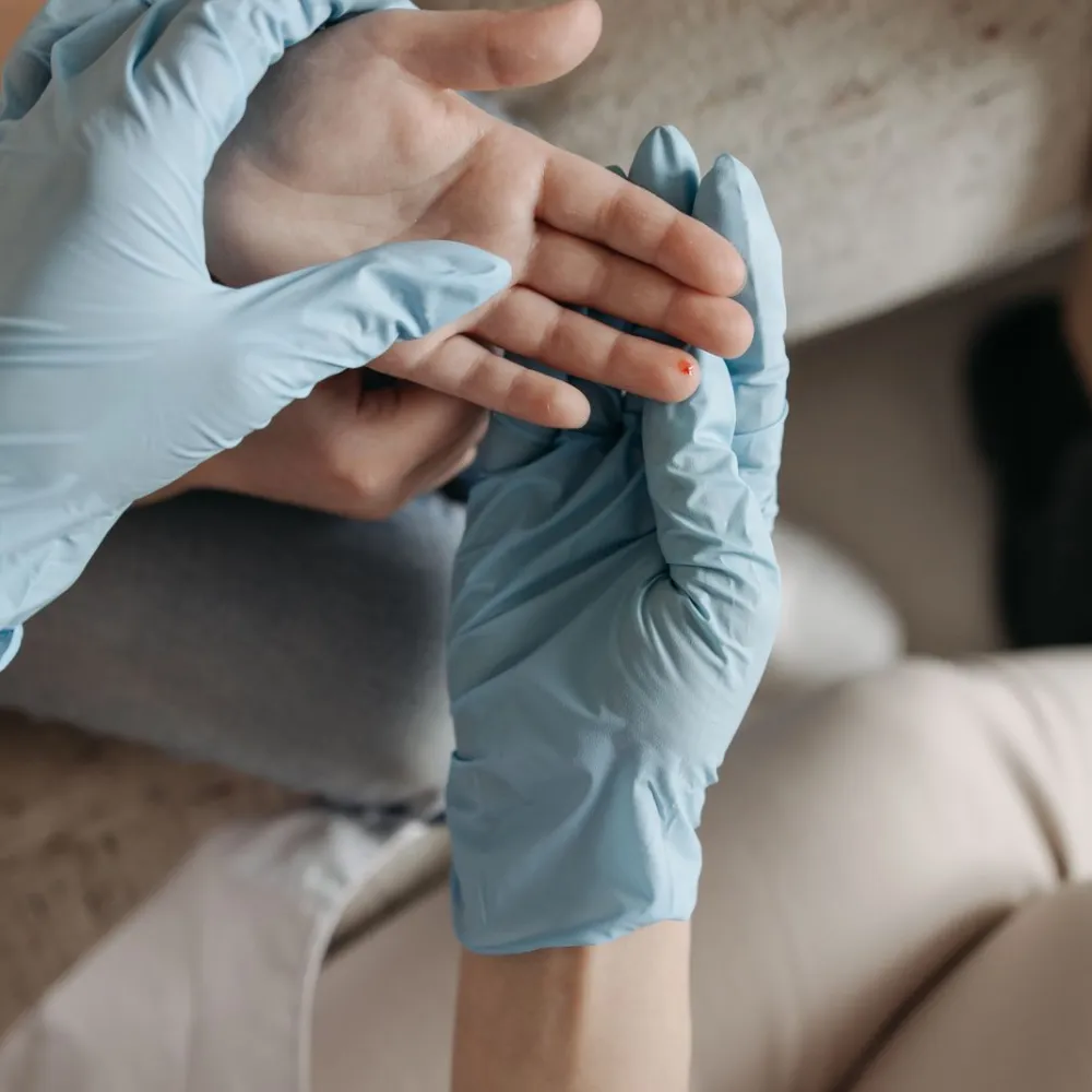 Clinician in blue gloves examining a small wound